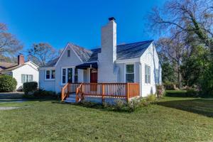 a white house with a wooden fence in the yard at Forest Acres Boho Home - 2BR in Columbia