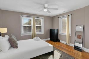 1 dormitorio con 1 cama blanca y 2 ventanas en Spacious Home on Gervais - 4BR, en Columbia