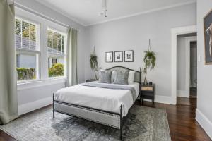 a white bedroom with a bed and two windows at Cottontown 3BR - Mins to USC in Columbia