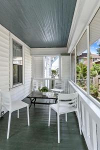 a porch with white chairs and a table at Cottontown 3BR - Mins to USC in Columbia