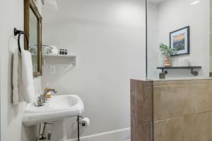 a bathroom with a sink and a mirror and a tub at 3BR on University Hill in Columbia +28 photos