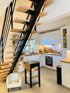 a kitchen with a spiral staircase in a house at MAZET RÉNOVE Golfe de st TROPEZ in Cogolin