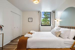 a white bedroom with a large bed and a window at Alchemist - The Vestry on Read in Columbia