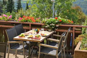 a table and chairs with food on a balcony with flowers at Hotel-Restaurant Kelter in Esslingen