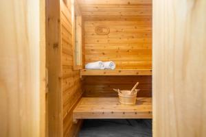 una sauna de madera con 2 toallas y un cubo en The Green Forest Retreat - Kayak, Hot Tub, Sauna en East Stroudsburg