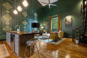 Una cocina con paredes verdes y un escritorio y sillas. en Gypsy - The Vestry on Read, en Columbia
