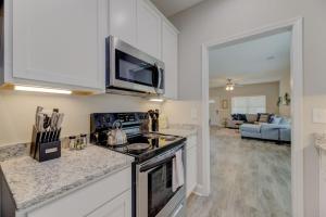 a kitchen with a stove top oven next to a living room at Cayce Sister Houses-Sleeps 14 in Cayce