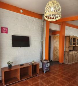 ein Wohnzimmer mit einem Flachbild-TV an der Wand in der Unterkunft la rosarina in Potrerillos