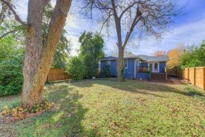 a yard with two trees and a blue house at Rose Hill Retreat-Mins to USC in Columbia