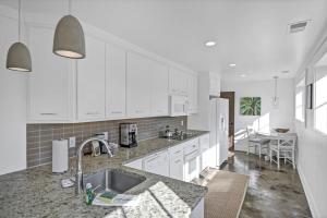 a kitchen with white cabinets and a sink at Historic Carriage House in Columbia