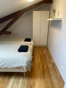 a bedroom with a bed and a cabinet and wooden floors at Private Rom for two in Oslo City center-Main Street-Walking distance in Oslo