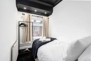 a bedroom with a bed with a mirror and a window at Dawlish House - Newly Refurbished Gem in Leeds