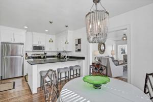 a kitchen with white cabinets and a table and chairs at Modern Gem in Columbia in Columbia