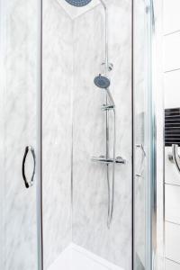 a shower with a glass door in a bathroom at Dawlish House - Newly Refurbished Gem in Leeds