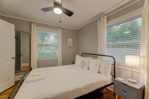 een slaapkamer met een wit bed en een plafondventilator bij Lounge On Lincoln-Pet Friendly in Columbia