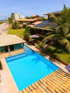 - une vue sur la piscine en face d'une maison dans l'établissement Pousada Cia do Peixe, à Marataizes