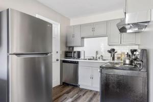 a kitchen with a stainless steel refrigerator and white cabinets at Humble Home on Harrison in Columbia