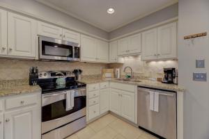 a kitchen with white cabinets and a stove top oven at Trendy Columbia Townhome in Columbia