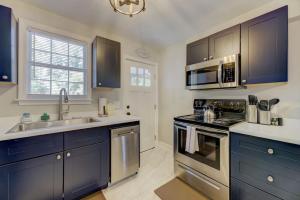 a kitchen with blue cabinets and a sink and a stove at Updated Columbian Cottage in Columbia