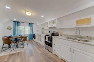 a kitchen with white cabinets and a table with chairs at Double-Suite Apartment Home in Columbia