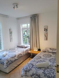 1 dormitorio con 2 camas y ventana en 31 Riverview en Ciudad del Cabo