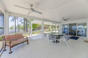 sala de estar con ventilador de techo, mesa y sillas en Modern Villa - Lake Views en Lake Murray Shores