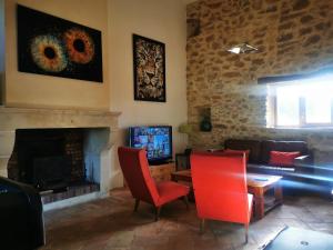 a living room with red chairs and a fireplace at Bastide du Barry - Centre historique de Vallon Pont d'arc in Vallon-Pont-dʼArc
