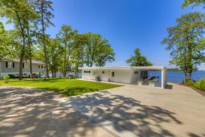 Modern Villa - Lake Views في Lake Murray Shores: مبنى ابيض كبير به اشجار وجسم ماء