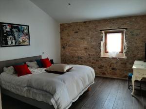 a bedroom with a bed and a brick wall at Bastide du Barry - Centre historique de Vallon Pont d'arc in Vallon-Pont-dʼArc