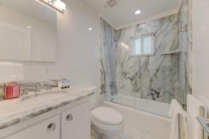 a white bathroom with a toilet and a sink at Modern Villa - Lake Views in Lake Murray Shores +33 photos