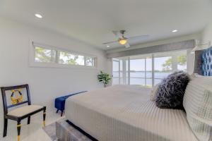 a bedroom with a bed and a chair and windows at Modern Villa - Lake Views in Lake Murray Shores