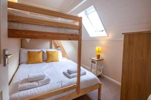 een slaapkamer met een stapelbed met gele kussens bij Isis Lakes 50, Natterjack Lodge - P in South Cerney