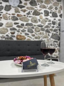 a table with a plate of food and two glasses of wine at Meraki house of kalymnos Apartments in Kalymnos