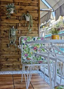 a chair on a porch with plants on a wooden wall at Caravin Wanderhome Acropolis, 1 min from Acropolis Museum in Athens