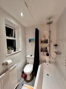 y baño con aseo y bañera. en Cosy bedroom in Central Cornwall, en Constantine