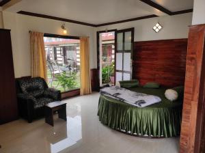 a bedroom with a bed and a chair in it at The Jacks Hilltop Kodai in Kodaikānāl