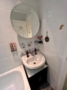 Baño blanco con lavabo y espejo en Cosy bedroom in Central Cornwall, en Constantine