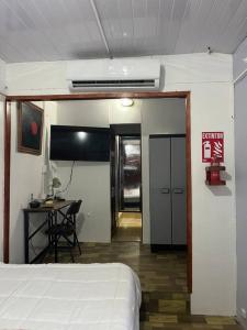 1 dormitorio con cama, escritorio y mesa en Churubusco Trailer en Vara Blanca