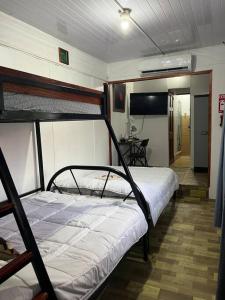 1 dormitorio con 2 literas y mesa en Churubusco Trailer en Vara Blanca