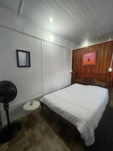 1 dormitorio con cama blanca y mesa en Churubusco Trailer en Vara Blanca
