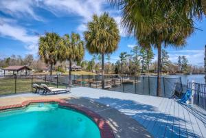 a swimming pool with a view of a river and palm trees at Lake Murray Lakeshore Lodge in Lake Murray Shores