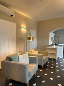 a living room with two couches and a kitchen at Divina Vita Apartments in Varenna