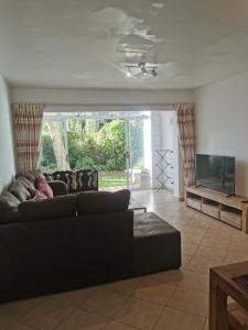 a living room with a couch and a flat screen tv at 31 Riverview in Cape Town