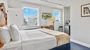 a bedroom with a white bed and a window at Crystal Bay Historic Hotel in St Petersburg