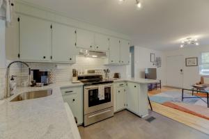 a kitchen with white cabinets and a stove top oven at Modern Renovated Apartment in Columbia +9 photos
