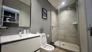 a bathroom with a toilet and a sink and a shower at Smart, Contemporary Designed Apartment in Cape Town