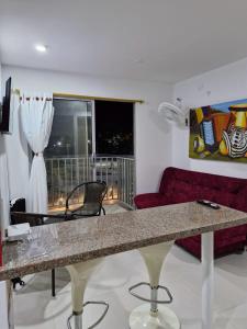 uma sala de estar com uma mesa e um sofá vermelho em Acogedor apartamento en Santa Marta em Santa Marta