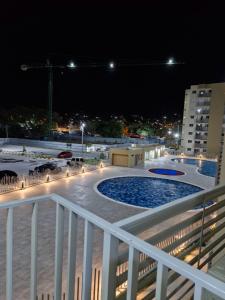 uma vista a partir de uma varanda à noite com uma piscina em Acogedor apartamento en Santa Marta em Santa Marta