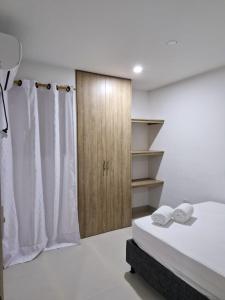 um quarto com uma cama e um armário com toalhas em Acogedor apartamento en Santa Marta em Santa Marta