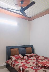a bedroom with a bed with a ceiling fan at Keshav Narayan Home Stay in Mathura